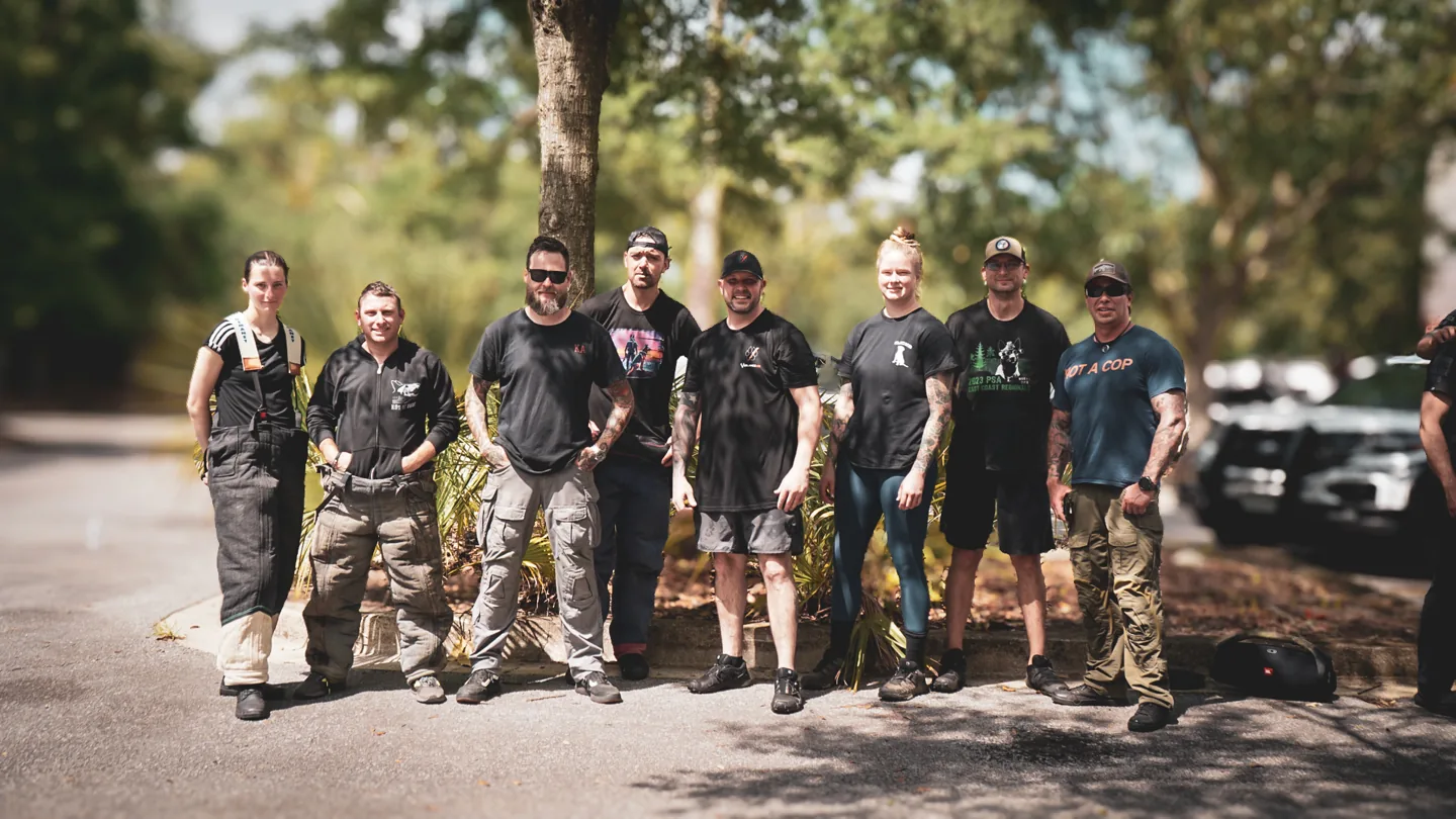 Seminar participants stand together with police K9s outdoors.