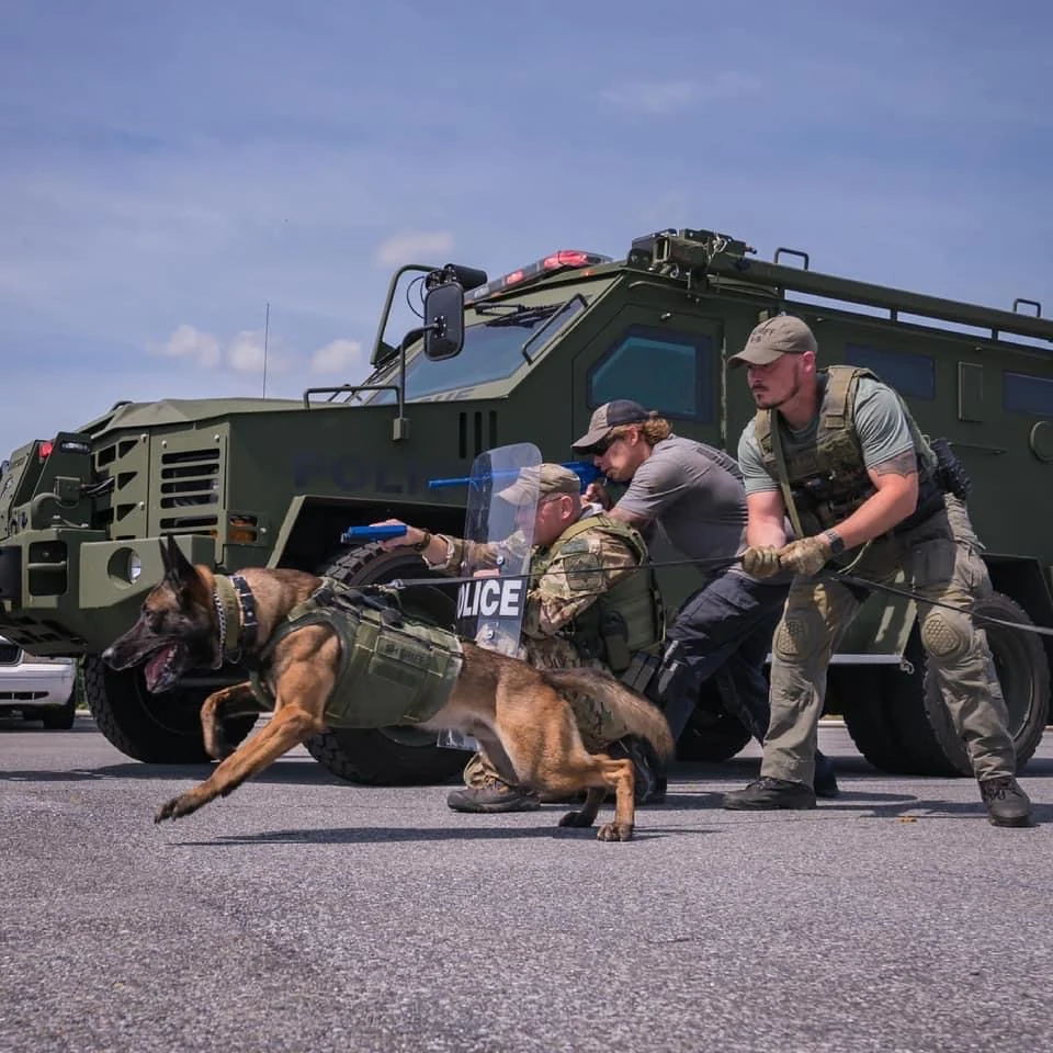 Handler, police K9 and supporting personnel working through a training scenario.