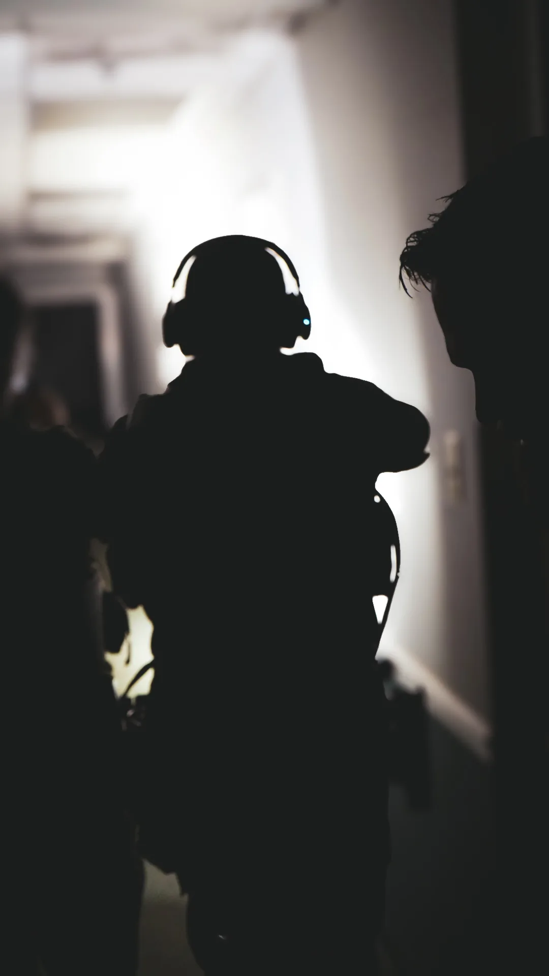 A handler silhouetted in the doorway of a training building.